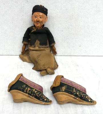 three pairs of shoes and a figurine of a man sitting on the ground