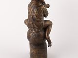an image of a bronze statue of a woman sitting on a stool