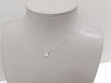 a white mannequin with a silver necklace on it