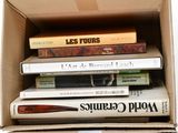 many books in a cardboard box on a white surface