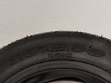 a close up of a tire on a white surface with a black rim