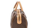 a brown and tan handbag sitting on top of a white surface