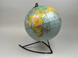 un petit globe terrestre posé sur un socle, sur fond blanc