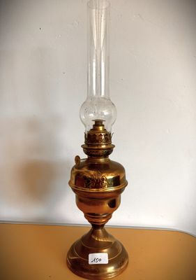 une petite lampe à huile posée sur une table, avec une étiquette de prix dessus