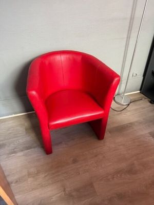 a red chair that is sitting in the corner of a room