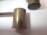two old brass objects on a white surface