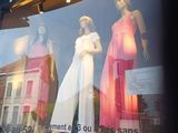 de nombreux mannequins dans la vitrine d'un magasin de vêtements