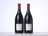 two bottles of red wine sitting next to each other on a table