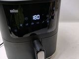 a black and silver air fryer on a white table
