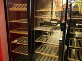 bottles of wine are lined up in a glass case in a store