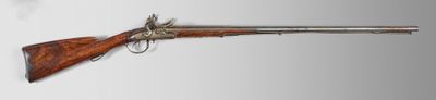 un vieux pistolet avec un canon en bois et une poignée en métal