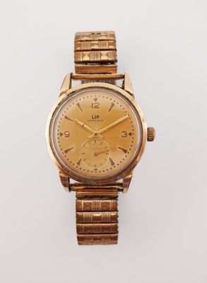 gros plan d'une montre-bracelet en or sur une surface blanche