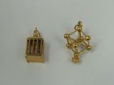 two pieces of gold plated metal with a cage on top of it