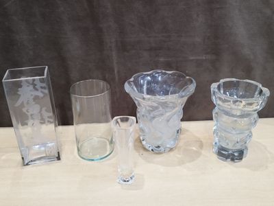 plusieurs vases et verres en verre posés sur une table devant un fond noir