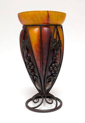 a vase that is sitting on a stand on a white surface