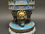a blue and gold vase with a lion head on it