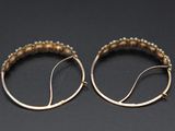 a pair of gold hoop earrings on a black surface