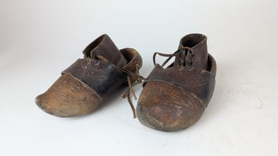 an old pair of shoes with laces on them sitting on a white surface