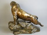 bronze statue of a lion on a rock on a white background