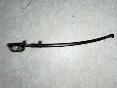 a black sword on the floor with a hook on it
