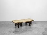 un banc en bois posé sur un sol en béton, près d'un mur blanc