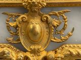 a gold and white clock with a bird on top of it