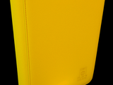 a yellow binder sitting next to a small white piece of paper