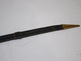 a black pen with a gold tip on a white surface