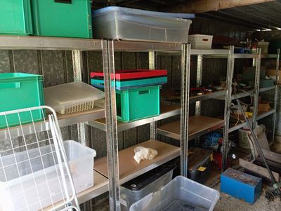 de nombreux bacs et cartons sur les étagères du garage