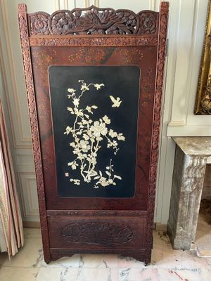 a tall wooden screen with a floral design on it