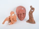 three clay figurines of a man, a woman, and a man