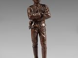 a bronze statue of a soldier with a helmet and a sword