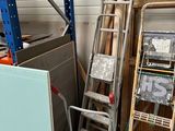 a ladder leaning against a wall next to a pile of assorted items