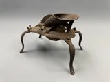 an image of a metal object on a table with a hat on it