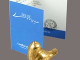 a gold bird figurine next to a business card holder