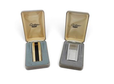 pair of gold and silver lighters in a case on a white surface