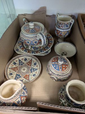 a cardboard box with many different types of pottery in it
