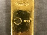un lingot d'or posé sur une table, sur fond blanc