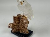 figurine d'une chouette blanche perchée sur une souche d'arbre