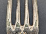 a silver fork with a design on it