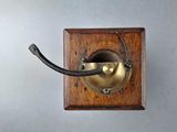 a small wooden box with a metal hook attached to it