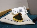 a gold ring with a green stone on it sitting on a bag