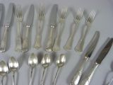 a lot of silverware on a table with a knife and fork