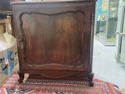 a wooden cabinet that is sitting on a rug