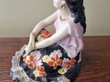 a figurine of a woman sitting on a table