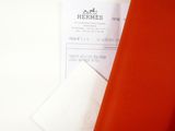 an orange piece of fabric next to a white piece of paper
