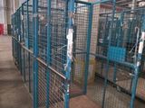 a large metal cage with a wooden floor in a warehouse