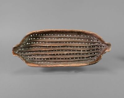 a close up of a brown and white bowl on a gray surface