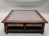 une photo d'une table basse en bois avec deux tiroirs et un plateau en verre