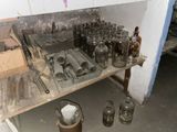 many glass jars sitting on a shelf in a room